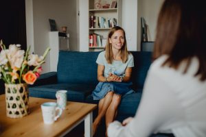 Stephanie sitzt auf der Couch und hat eine Klientin zu einer Beratung zu Besuch